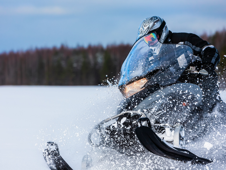 snowmobile travelling through snow, across a frozen lake