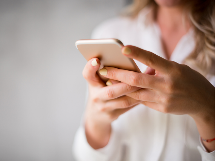 two female hands texting on a cellphone, slightly out of frame