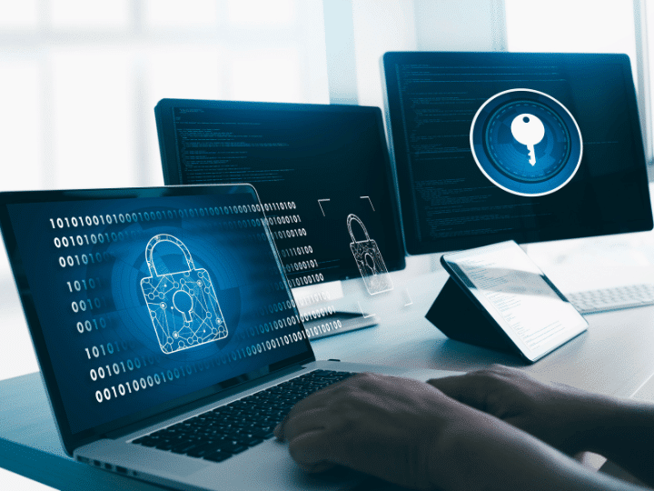 A cybersecurity professional works on a laptop with digital locks and a key symbol on the screen, symbolizing digital security measures.