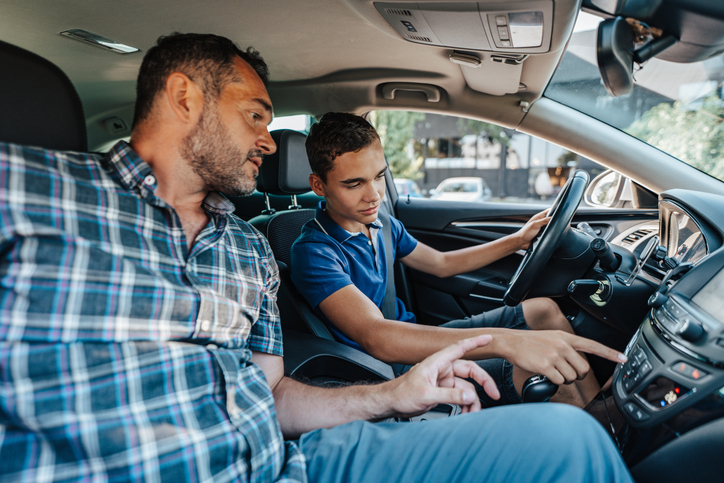 A G1 driver, accompanied by a supervising driver in the passenger seat, demonstrates the basic vision and knowledge standards required for safe driving.